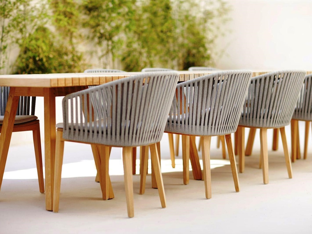 Wooden dining table with 8 beige slatted charis at villa masseria dei papi in Puglia, Italy