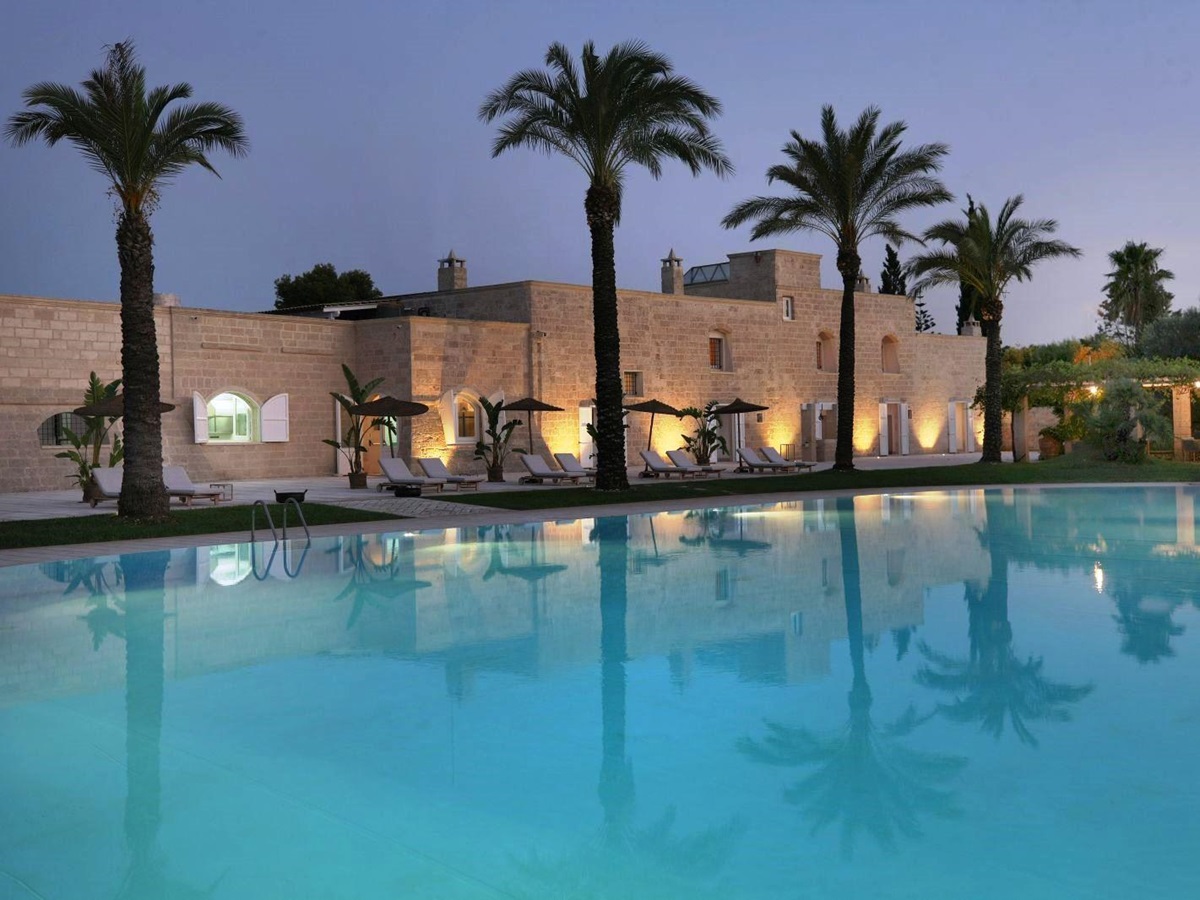 View over pool at sunset of the exterior of villa masseria dei papi in Puglian, Italy