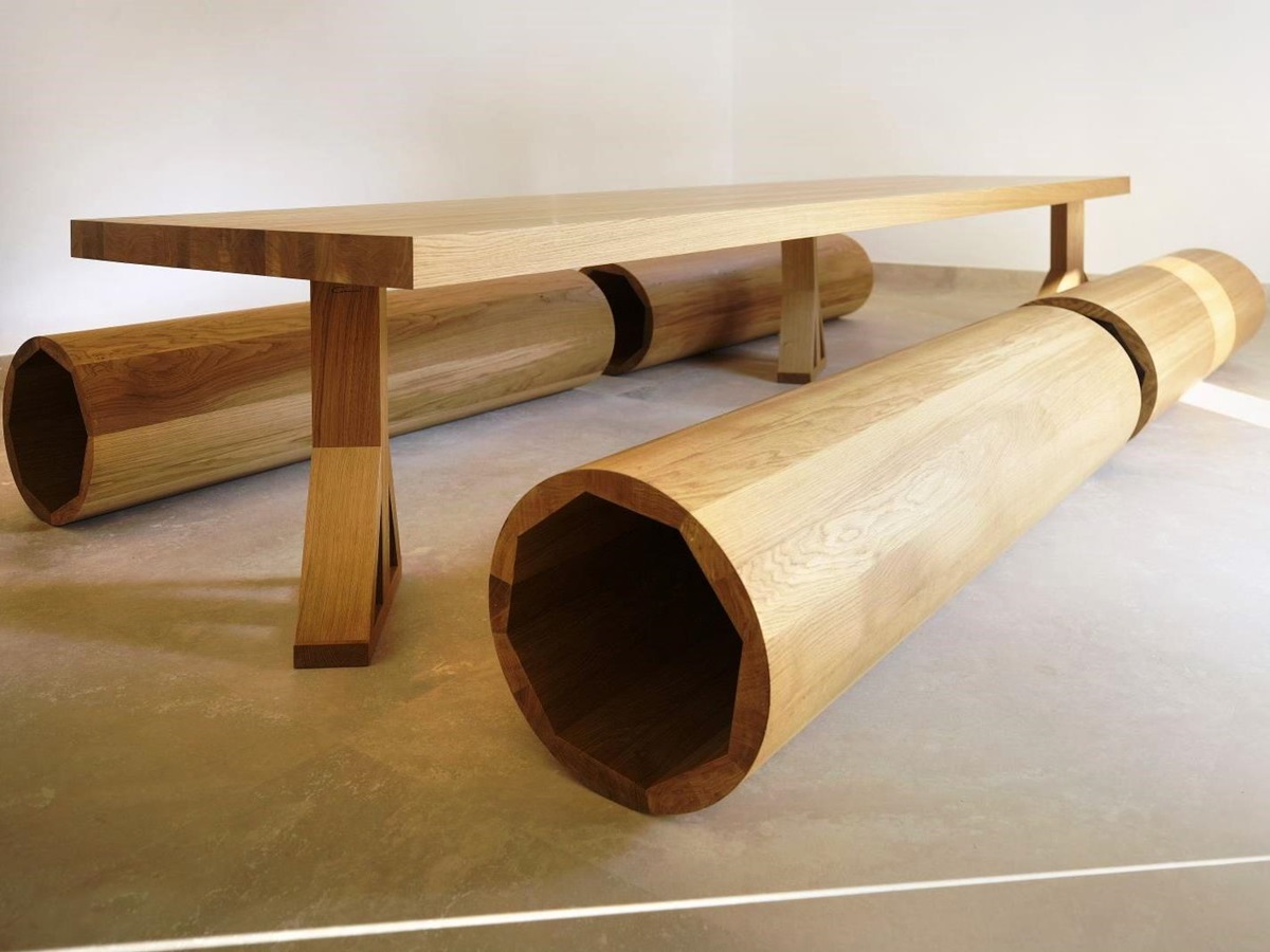 Designer wooden dining table and four circular wooden seats at villa masseria dei papi in Puglian, Italy