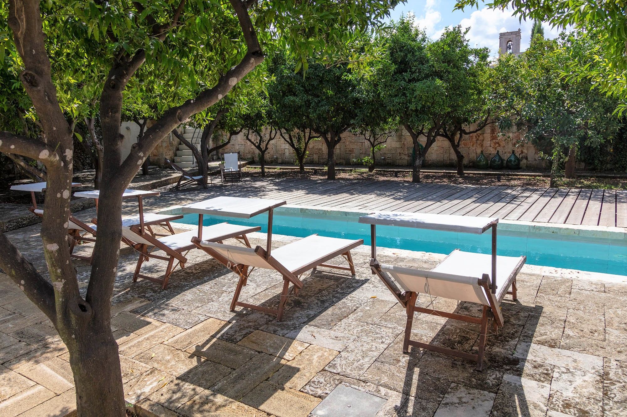 Pool area with loungers at Palazzo del Duca