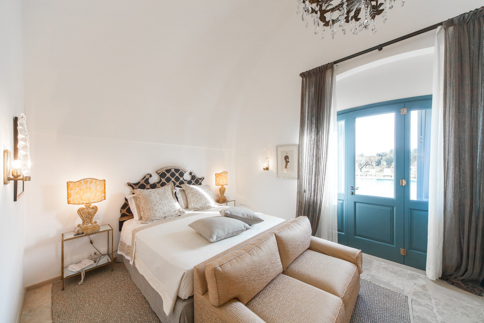 A double bedroom with azure blue door leading to the garden of Residenza Pettolecchia, Puglia