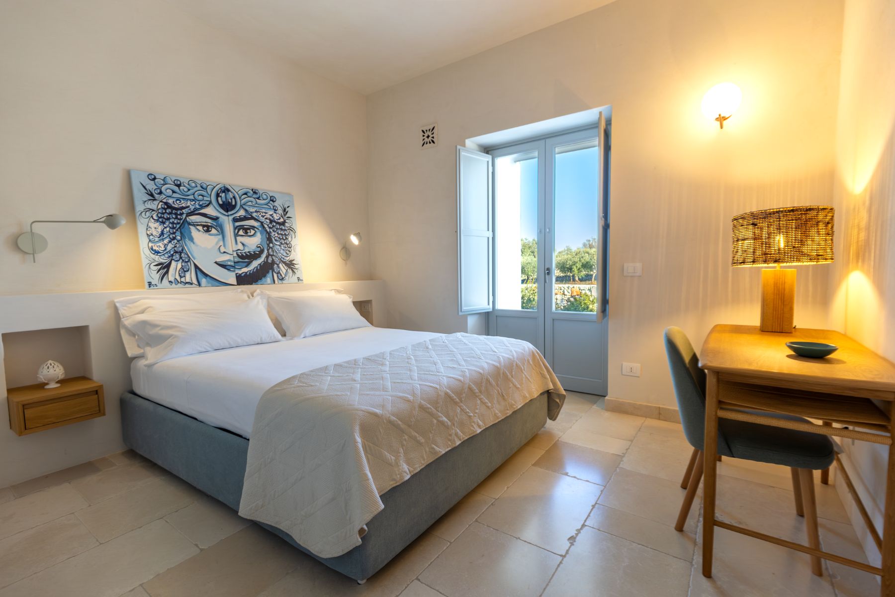 Double bedroom with artwork and garden view at Trulli Armonia in Puglia