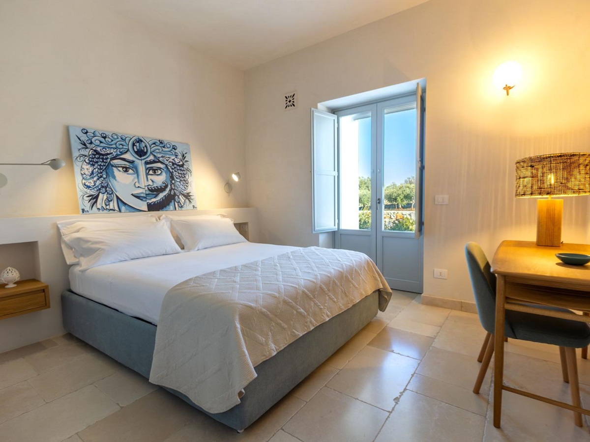 Double bedroom with artwork and garden view at Trulli Armonia in Puglia