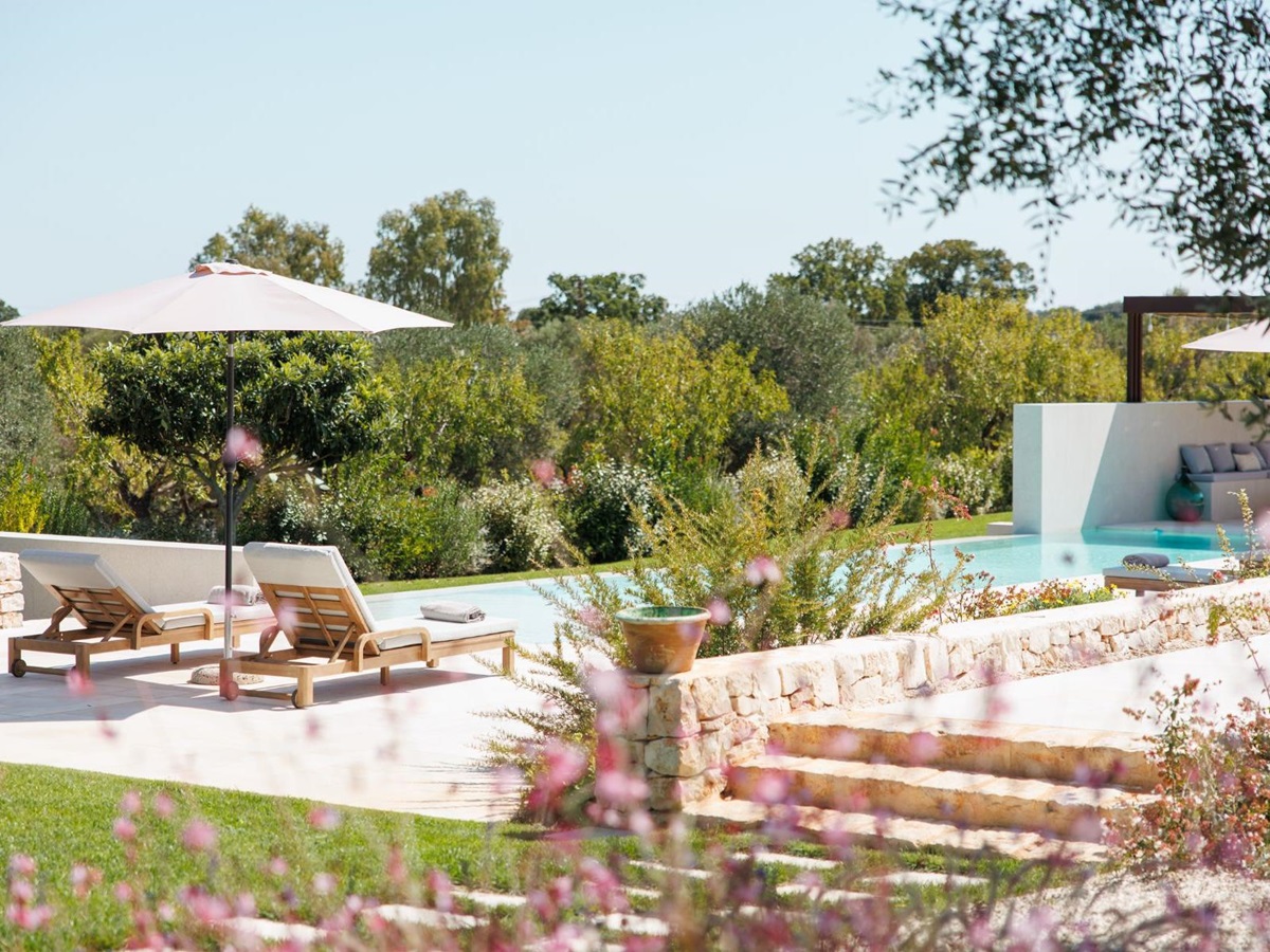 Sun loungers and flowerbed at Trulli Armonia in Puglia