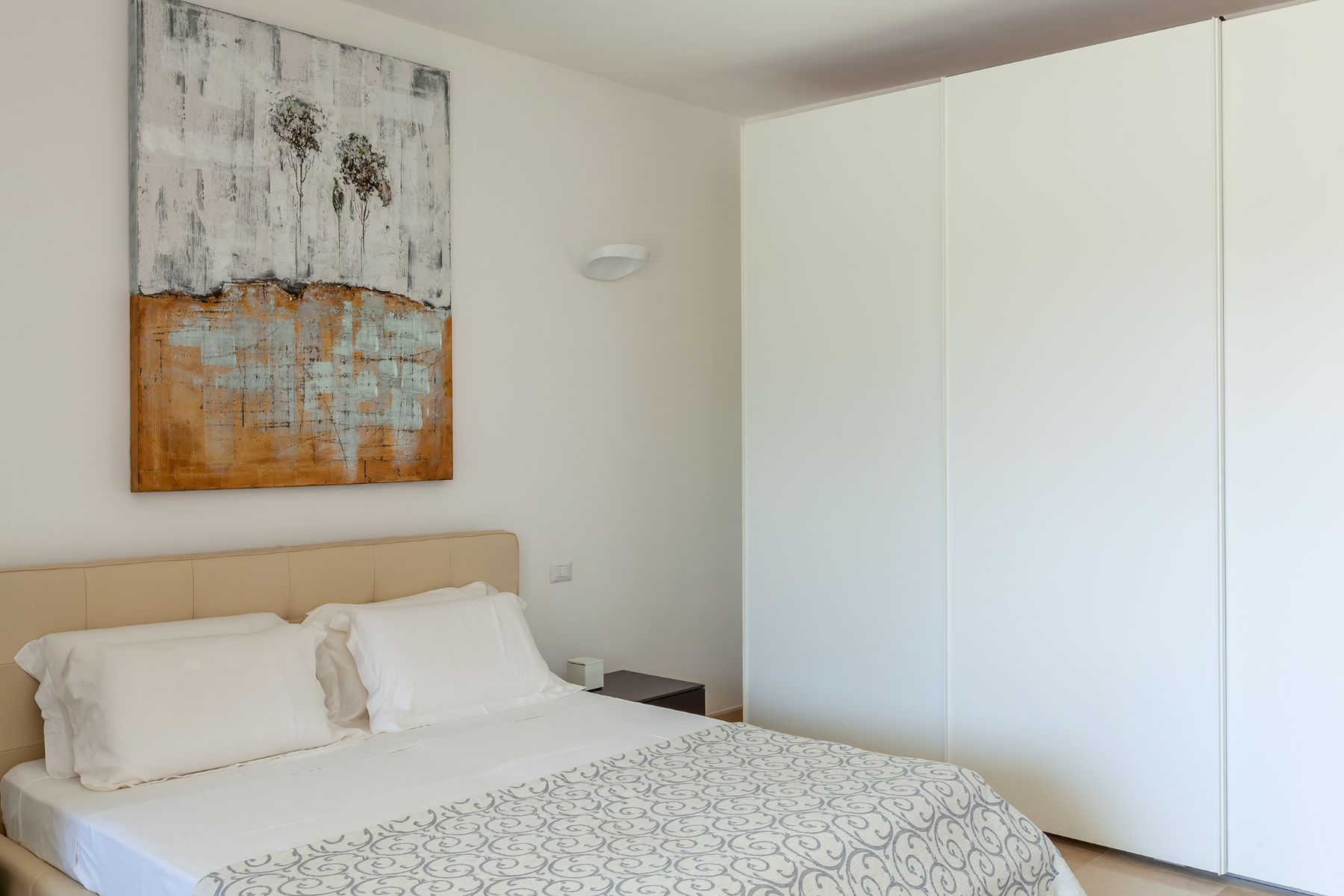 Double bed with grey cover at Trulli Lucia in Puglia