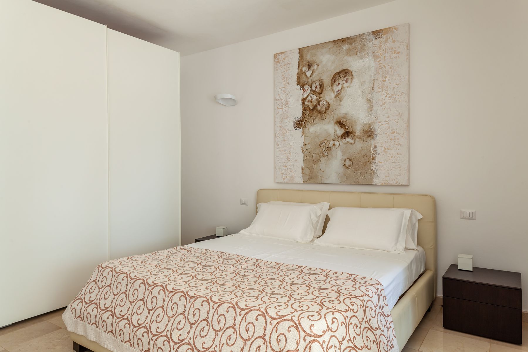Double bed with brown cover and wardrobe at Trulli Lucia in Puglia