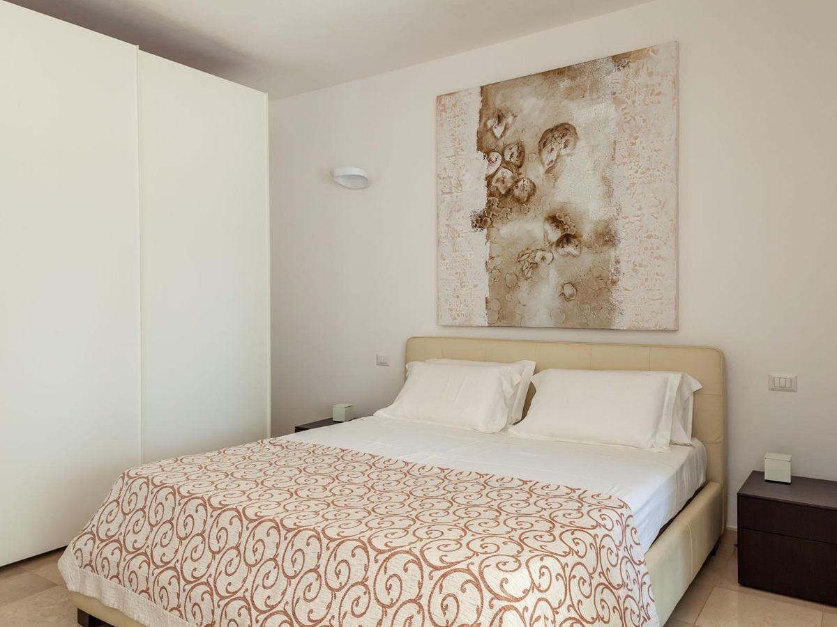 Double bed with brown cover and wardrobe at Trulli Lucia in Puglia