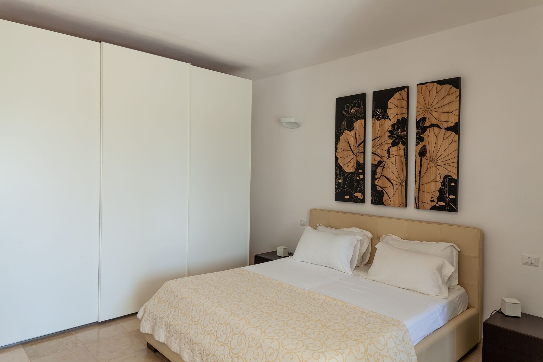 Doubled bed with yellow covers and wardrobe at Trulli Lucia in Puglia