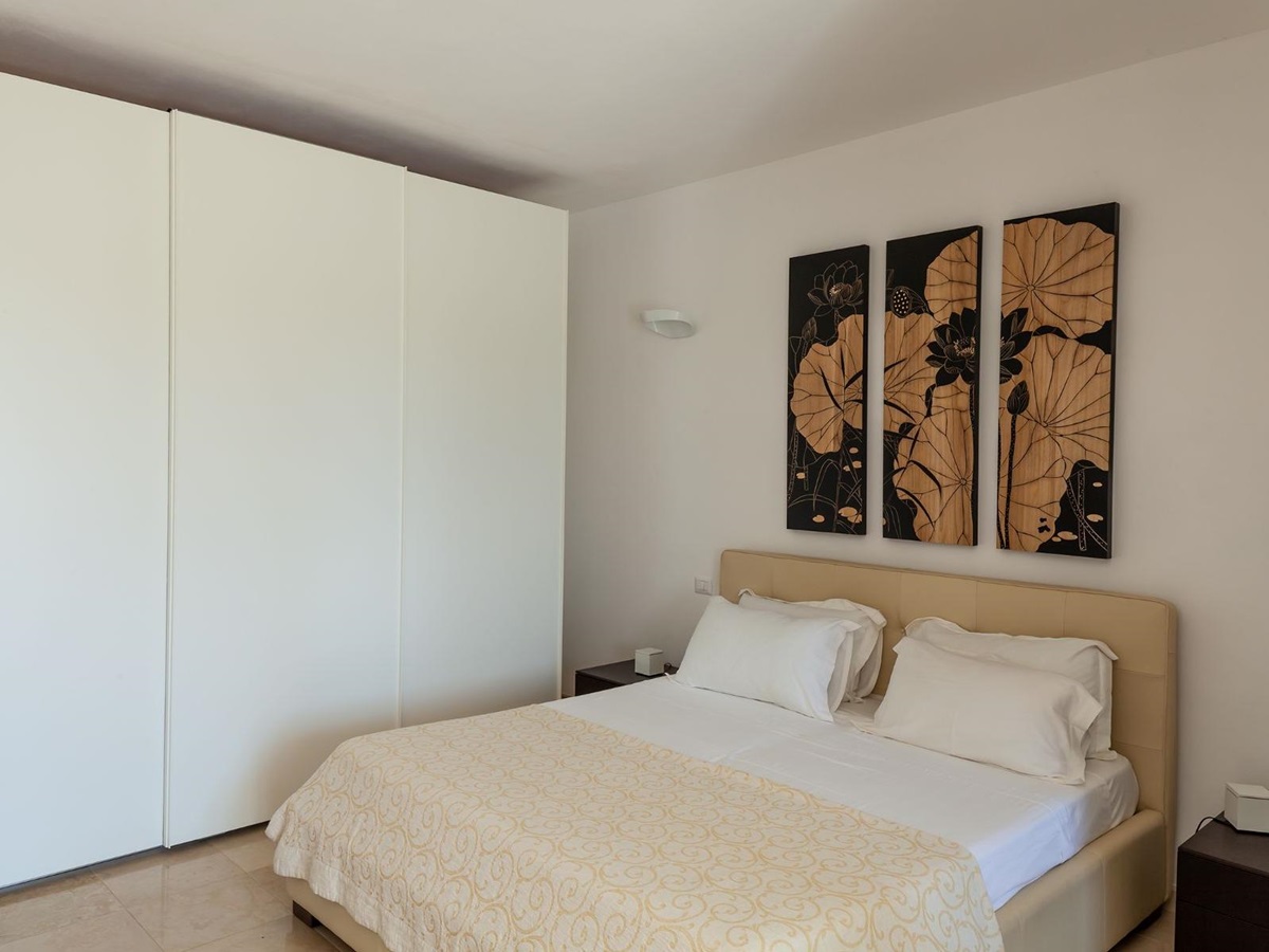 Doubled bed with yellow covers and wardrobe at Trulli Lucia in Puglia