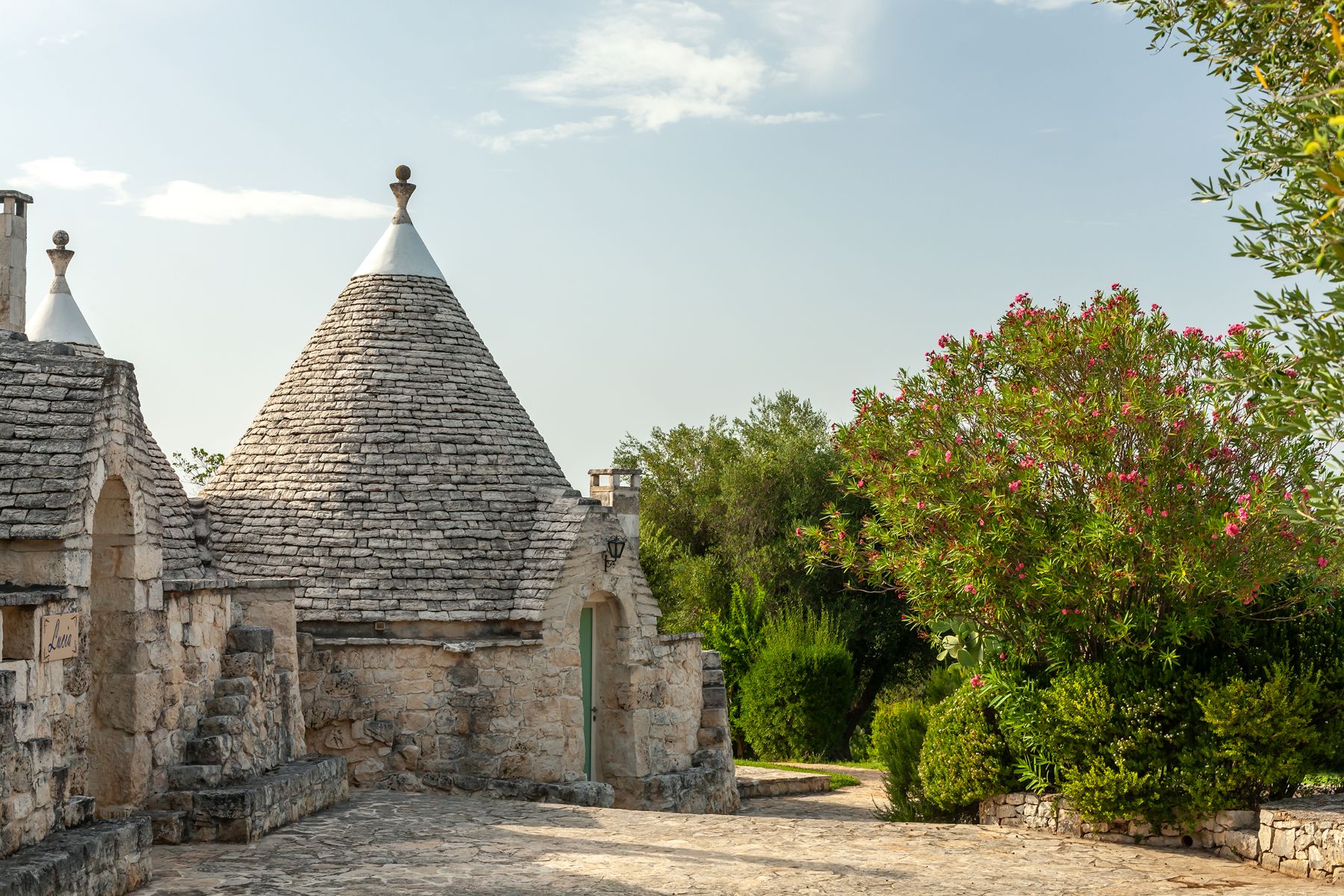 Exterior side view and trees at Trulli Lucia in Puglia