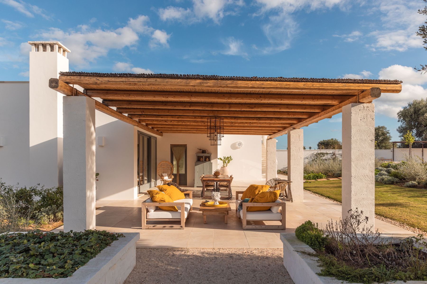 Outdoor lounge area at Villa Oliva in Puglia with view of outdoor sofas infer a wooden roof