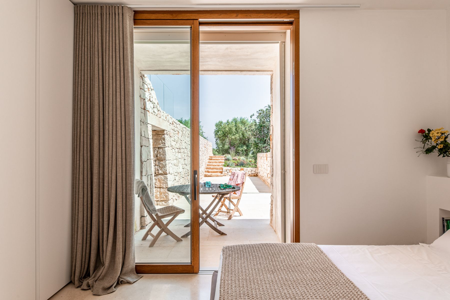 Bedrooms with open doors to the patio at Villa Venere in Puglia
