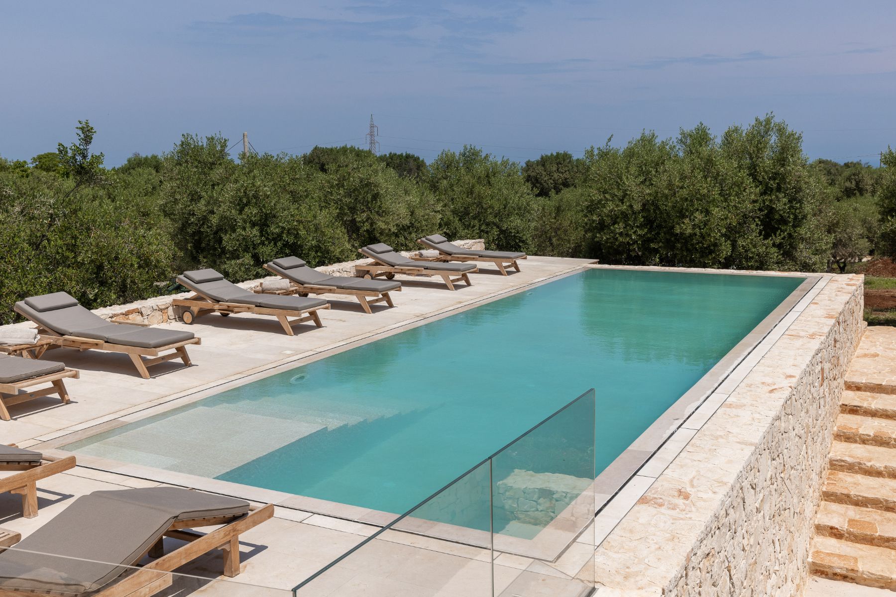Outdoor swimming pool at Villa Venere in Puglia with view of sunbeds and stone stairs