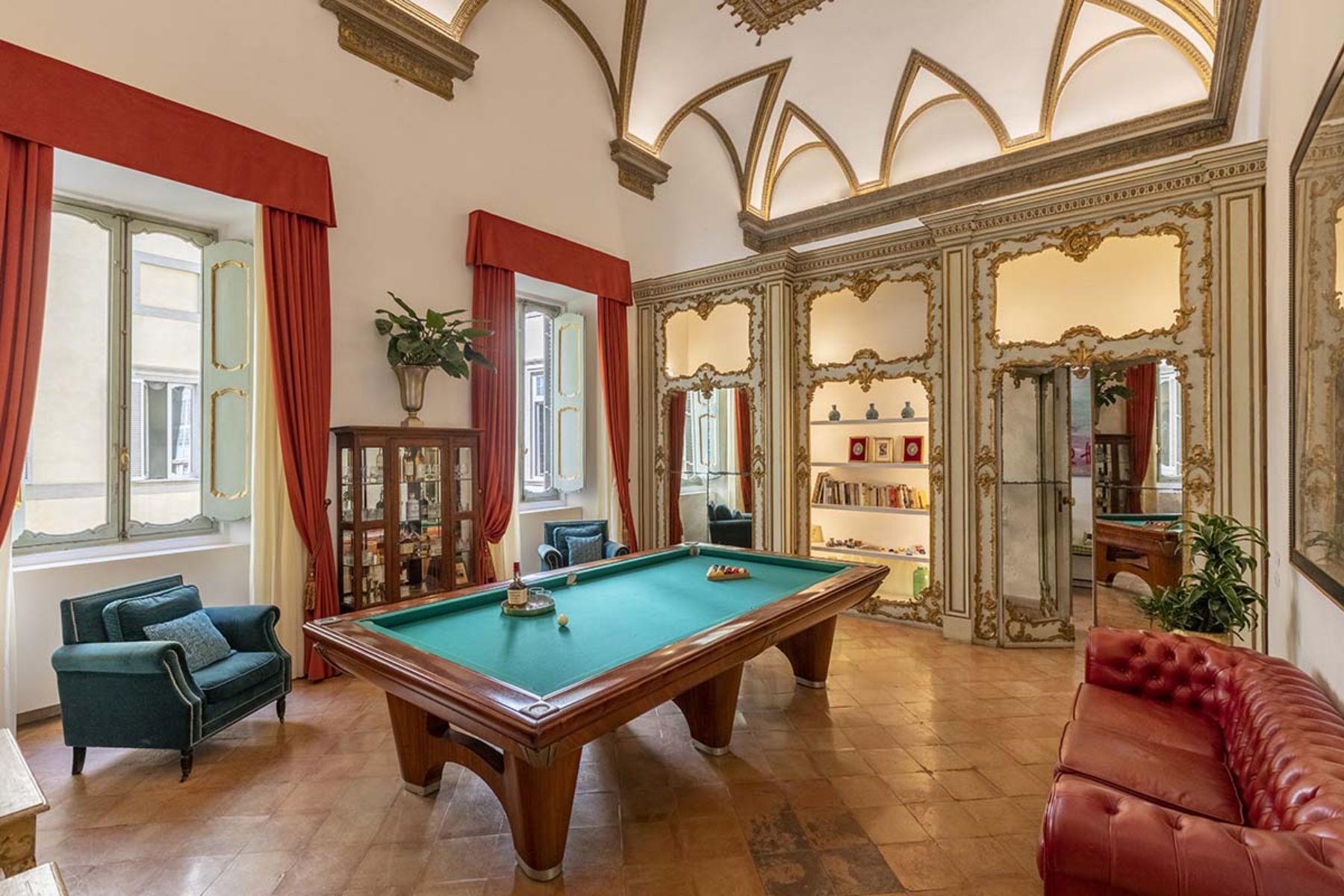 Billiard room at the Costaguti Apartment in Rome featuring a pool table in the middle and sofas at the side of the room