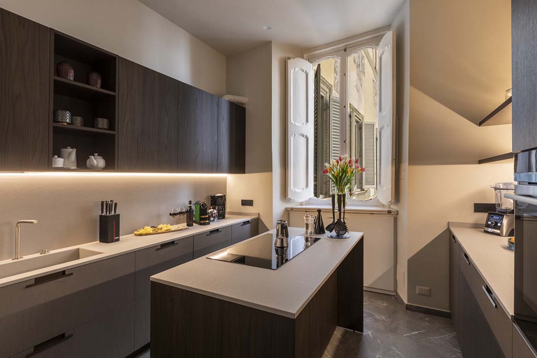 Modern kitchen at the Costagtui Apartment in Rome featuring island in the middle and open windows