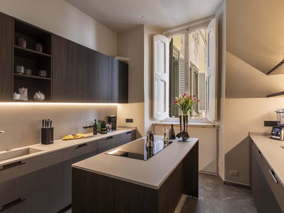 Modern kitchen at the Costagtui Apartment in Rome featuring island in the middle and open windows