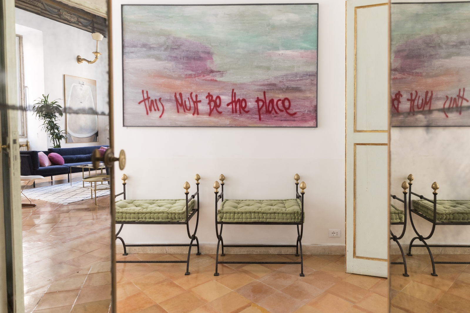 hallway with two cushioned stools and artwork at costaguti apartment, Rome