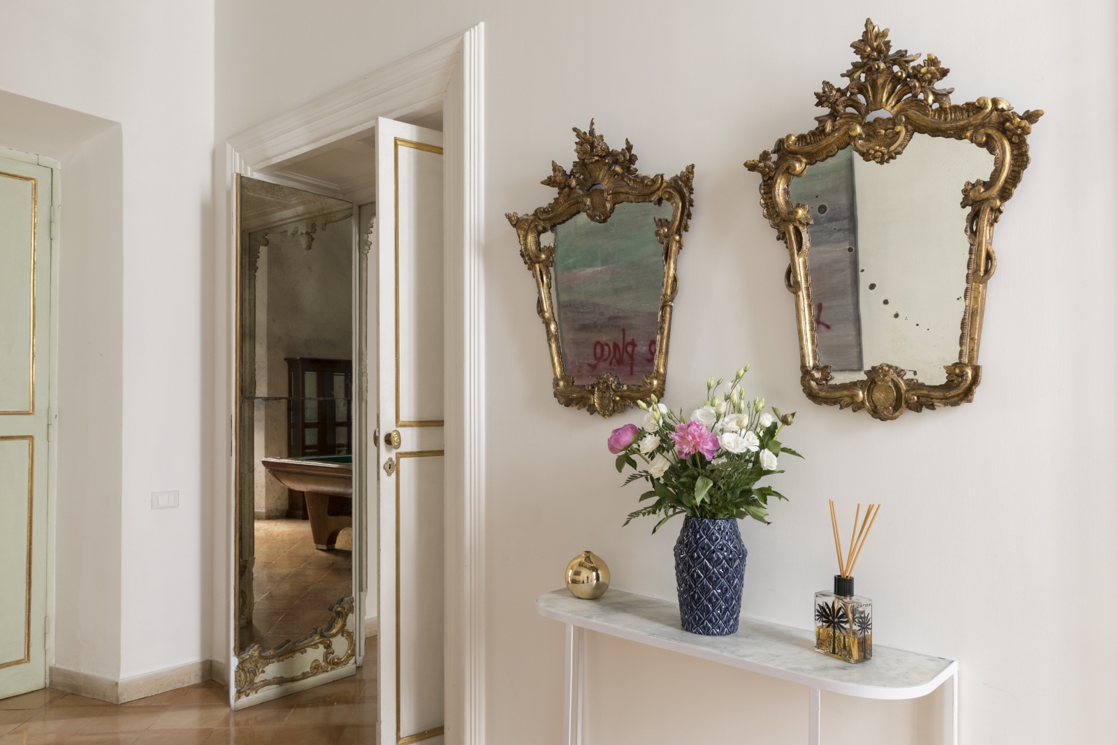 hallway with ornate gold mirros and flowers at costaguti apartment, Rome