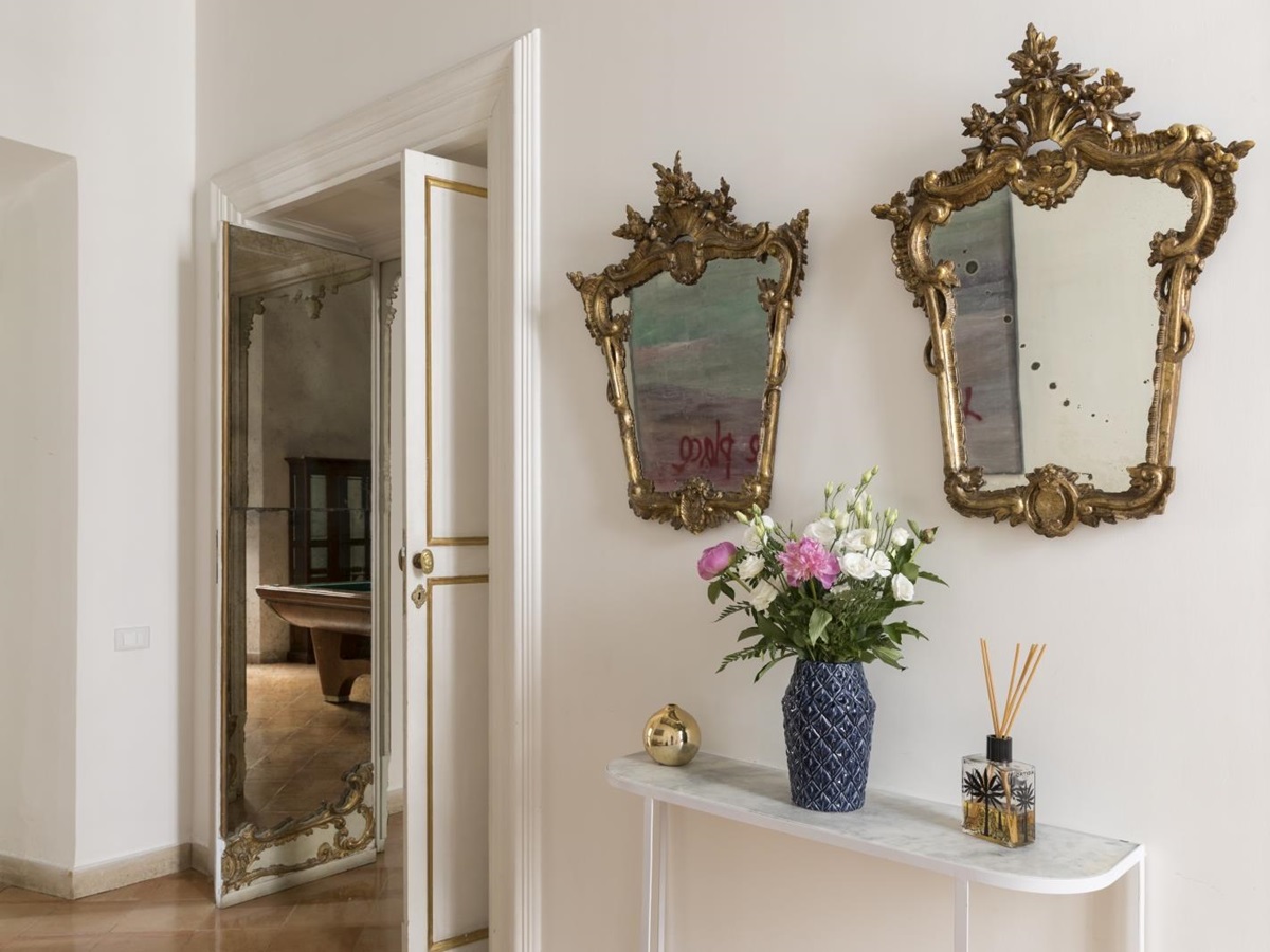 hallway with ornate gold mirros and flowers at costaguti apartment, Rome