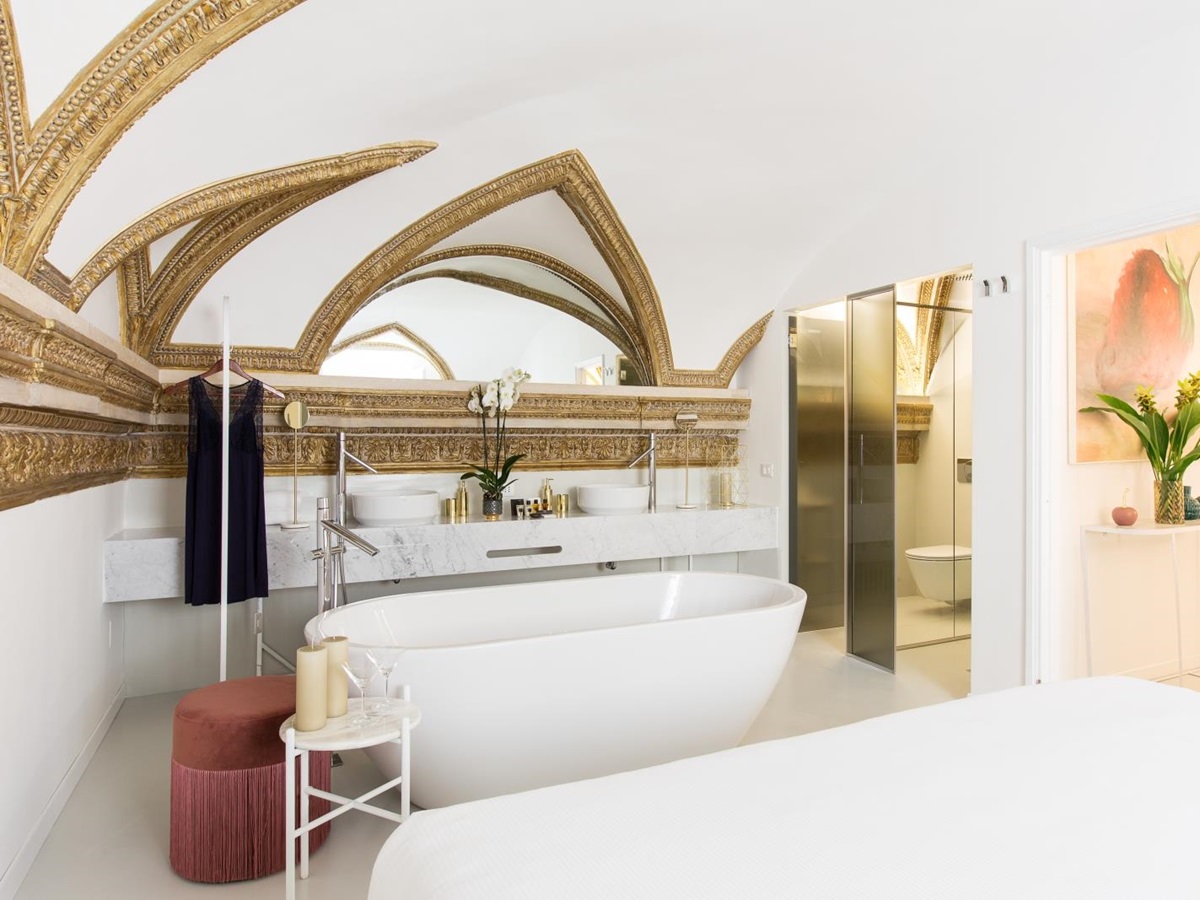bathroom with large white tub and arched ceiling at costaguti apartment, Rome