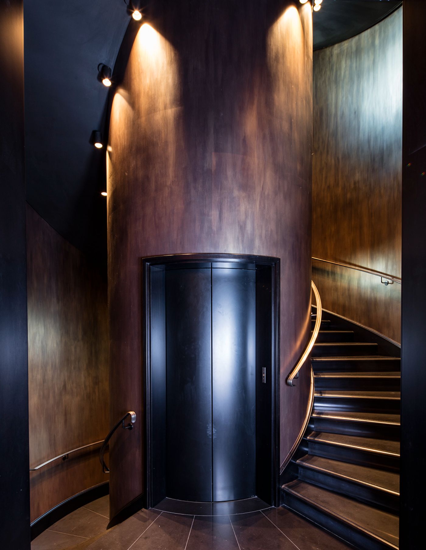 The elevator doors of Villa Clara, set inside the column of the spiral stairs.