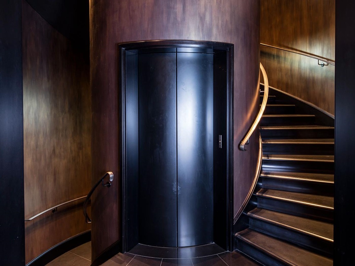 The elevator doors of Villa Clara, set inside the column of the spiral stairs.