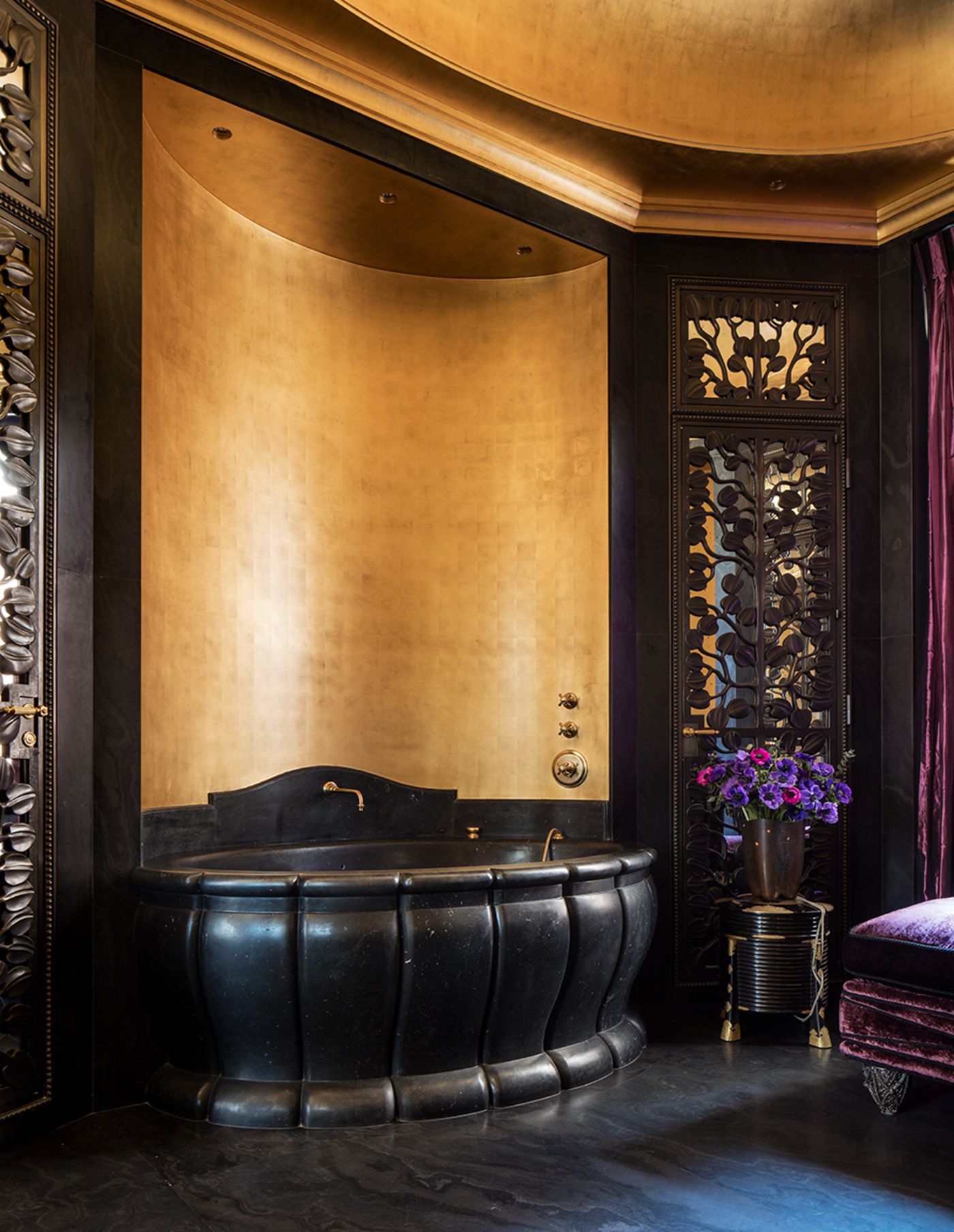 A large black bath tub in a bedroom ensuite at Villa Clara.