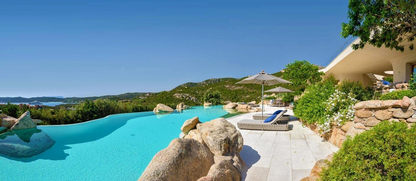 Large pool with loungers and sea views at The Rock in Sardinia