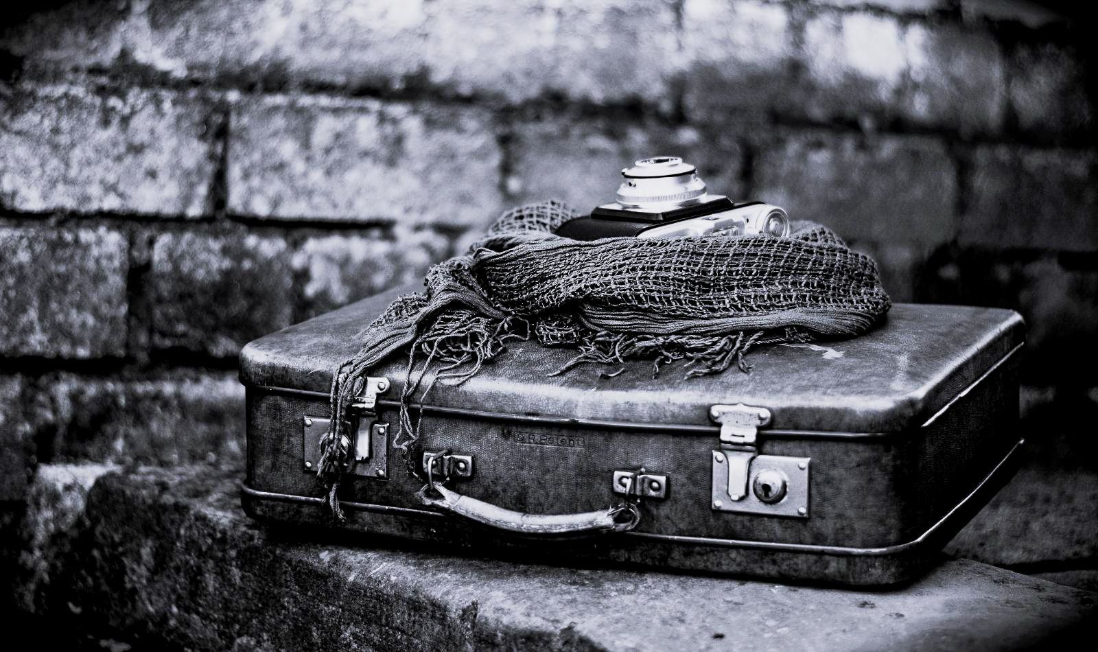 A darkened image of a camera and suitcase in Italy