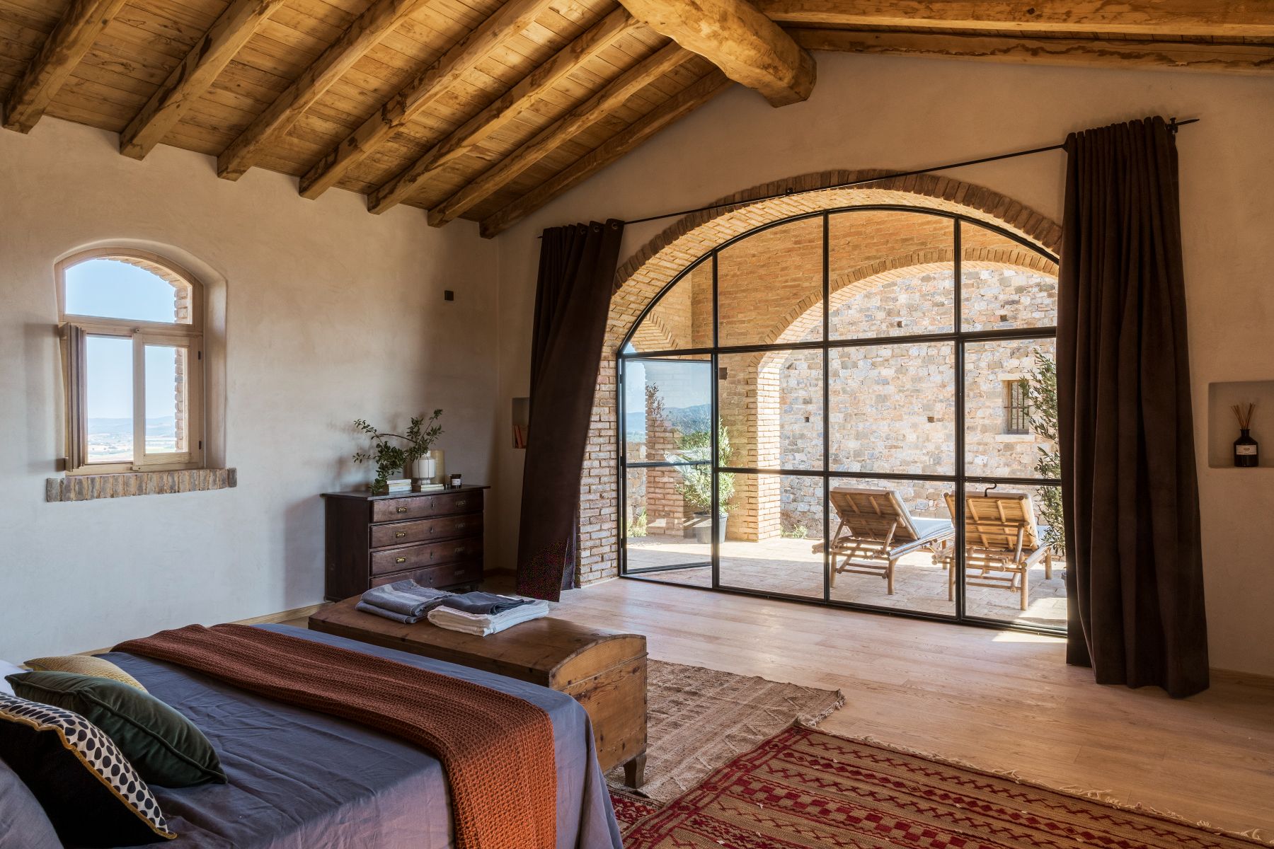 Bedroom with sun lounger terrace at Borgo Rinato in Tuscany
