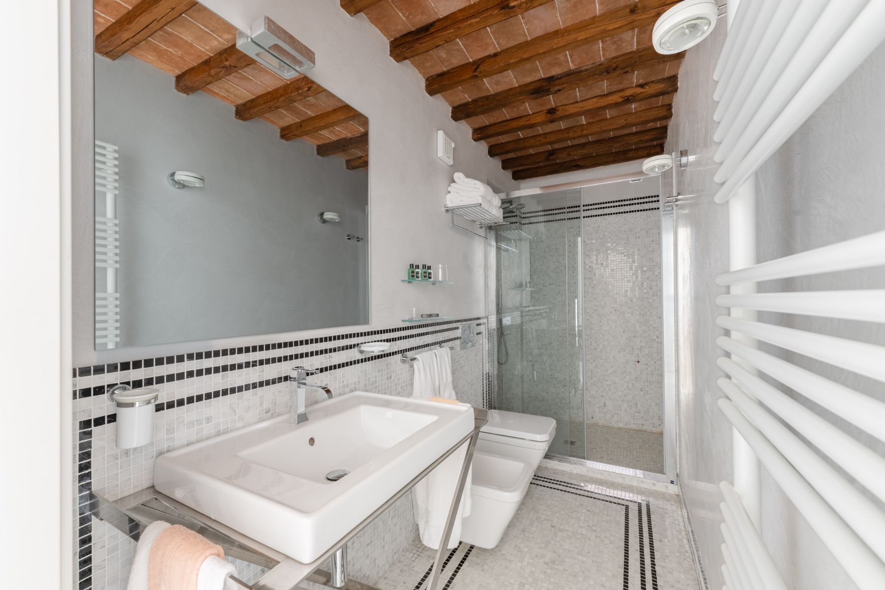 Modern bathroom with grey tiles, featuring a shower and basin in villa Il Mugnello in Tuscany