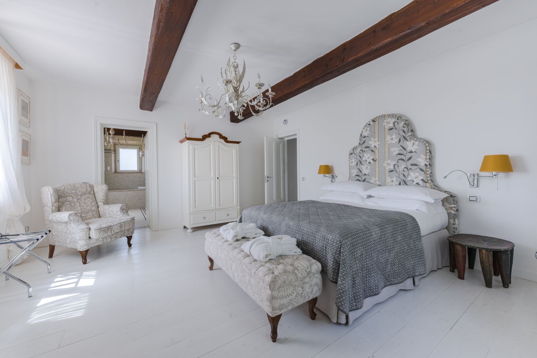 Bedroom with large double bed and modern decor, featuring a white wardrobe in villa Il Mugnello in Tuscany