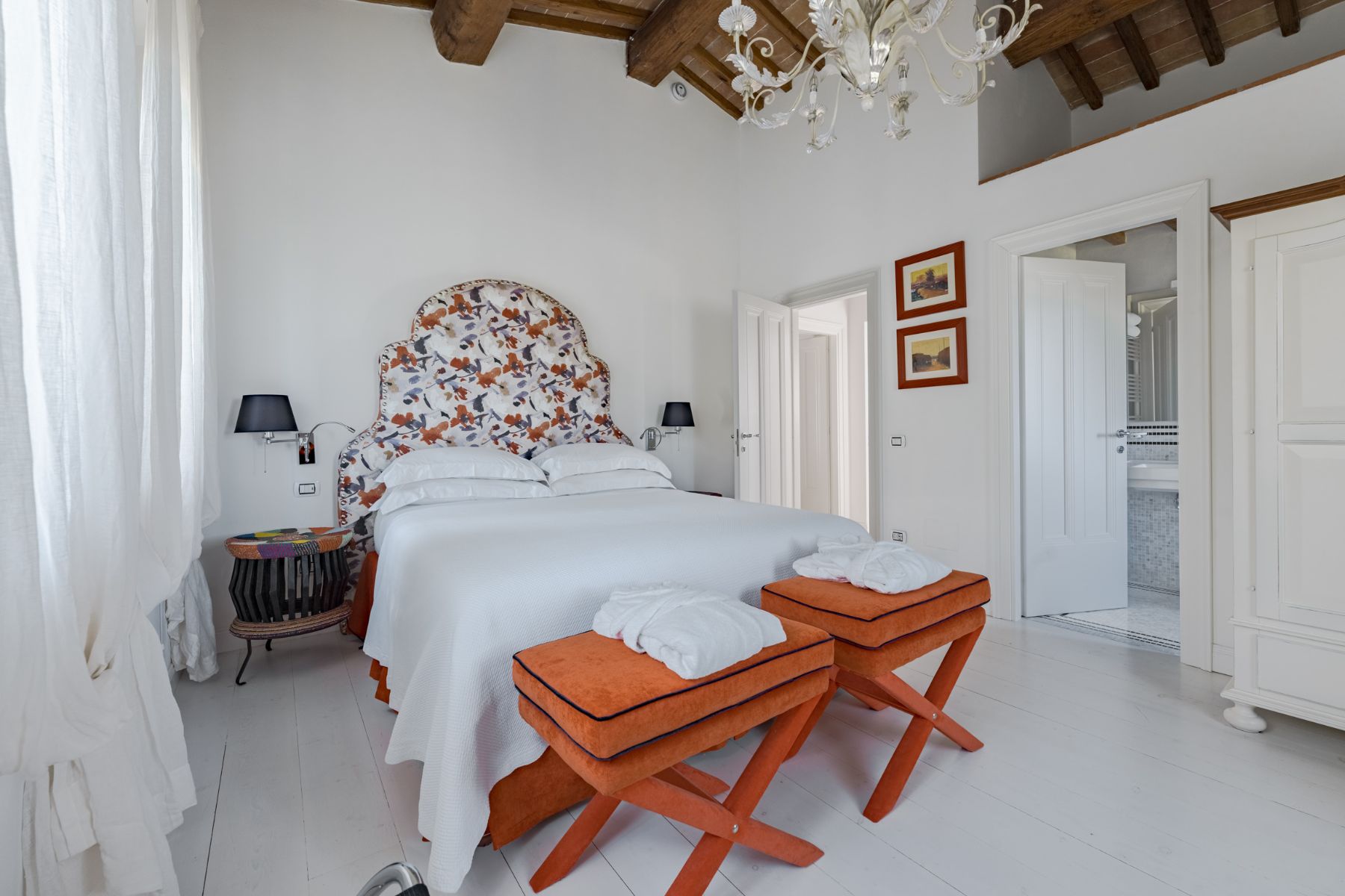 Bedroom with white walls and bedding at Villa Il Mugnello in Tuscany