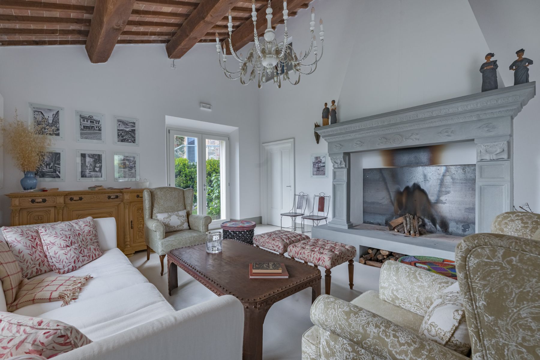 Large fireplace in living area featuring sofas and a chandelier in Villa Il Mugnello in Tuscany 