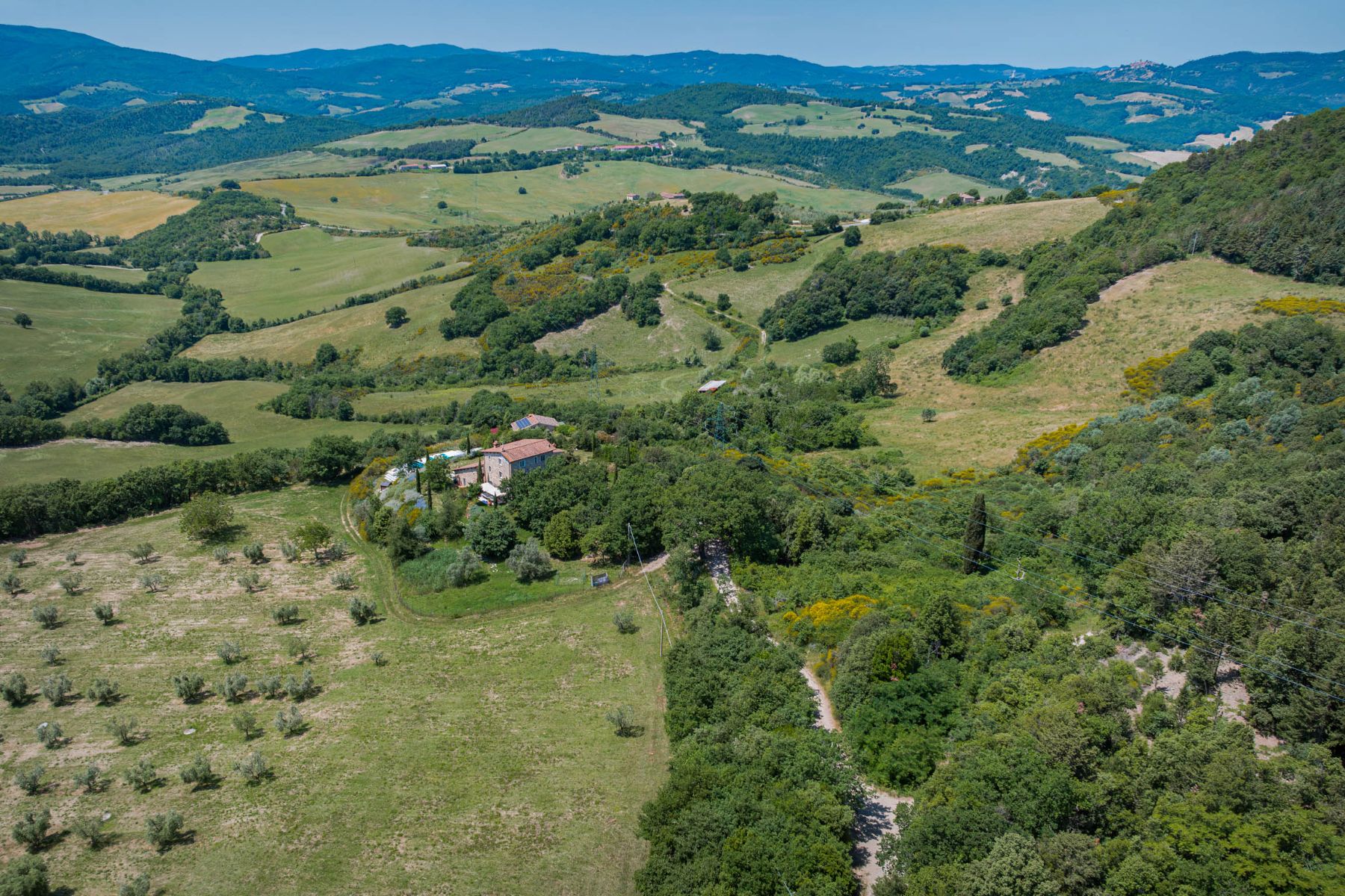 Landscape view of Villa Il Mugnello surrounded by hills and fields with view of Villa Il Mugnello