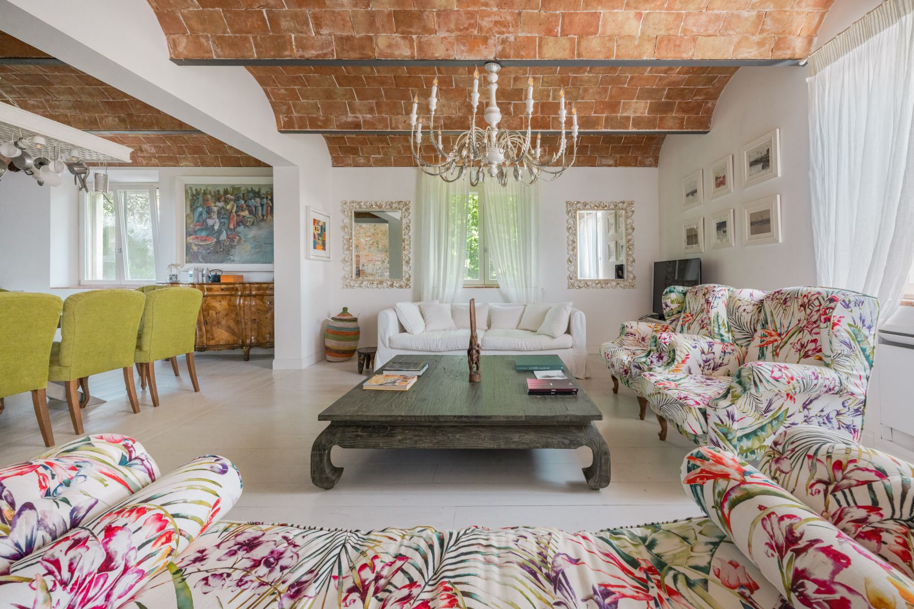 View of the living room featuring colourful sofas and a table in the middle at Villa Il Mugnello in Tuscany