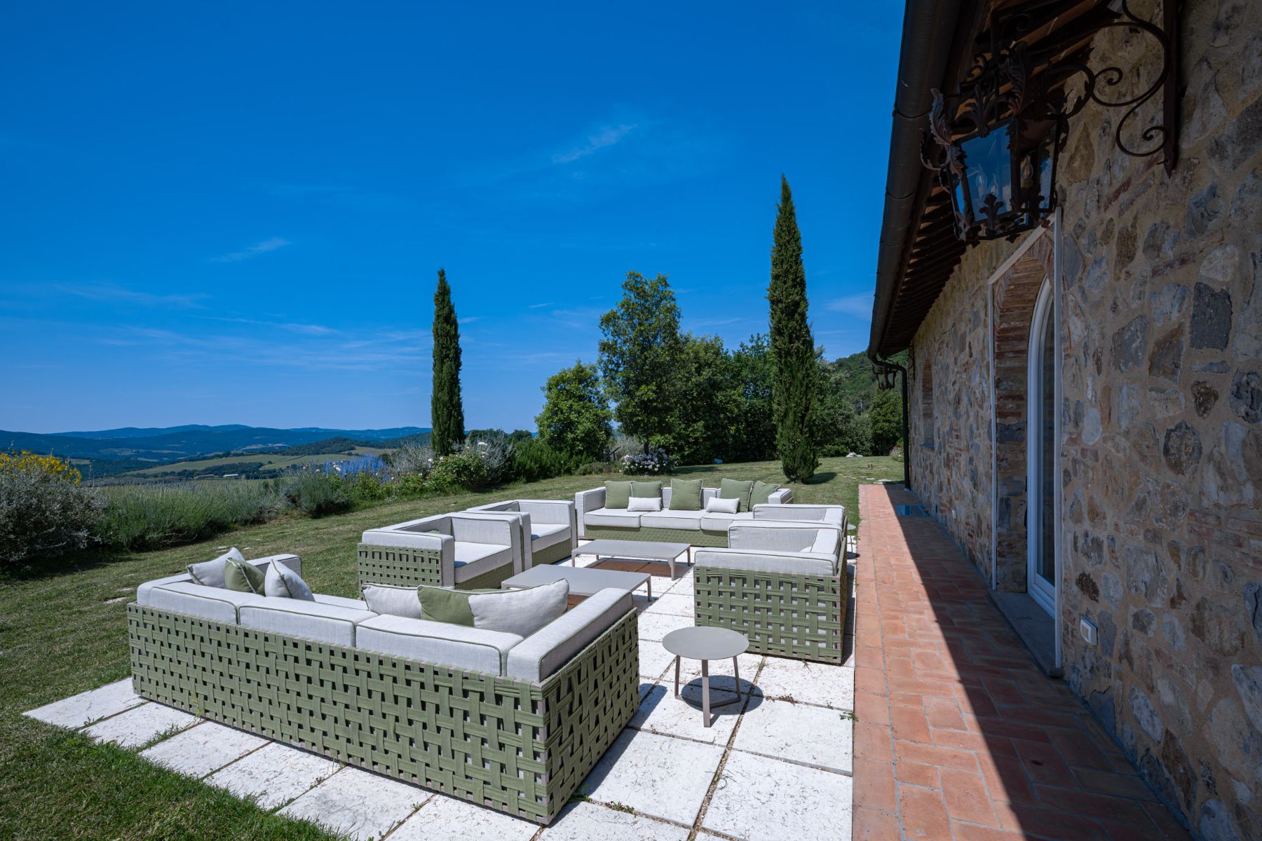 Outdoor seating area with view of the Tuscan hills in the background at Villa Il Mugnello in Tuscany