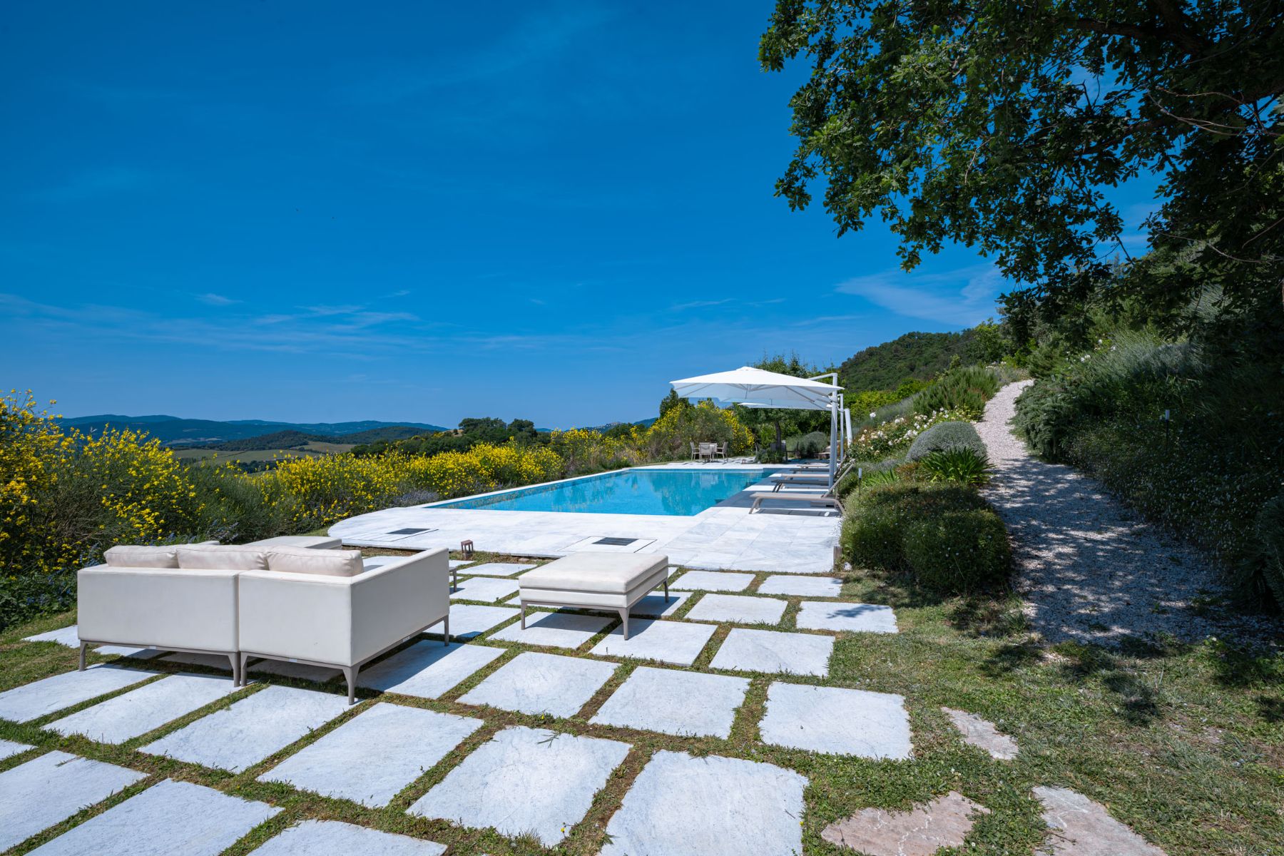 View of the outdoor garden patio tiles near the swimming pool at Villa Il Mugnello in Tuscany