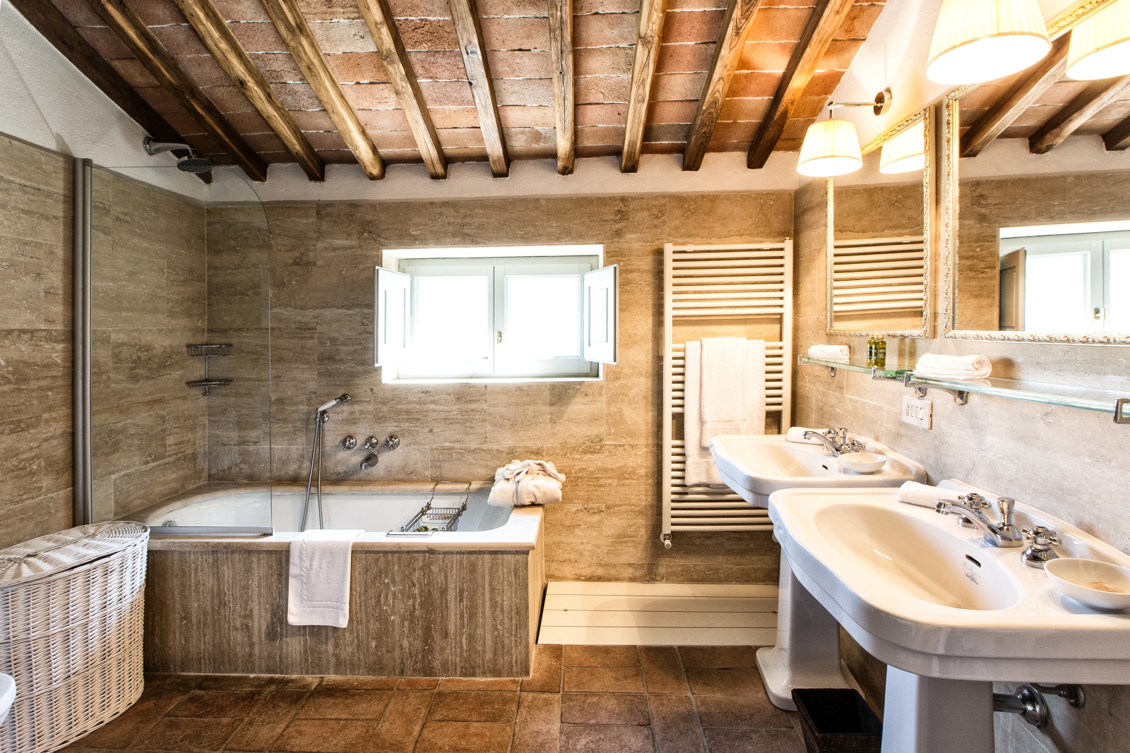 Bathroom with two sinks, two mirrors, towel rail, window and bath at Il Prato di Vignamaggio in Tuscany, Italy