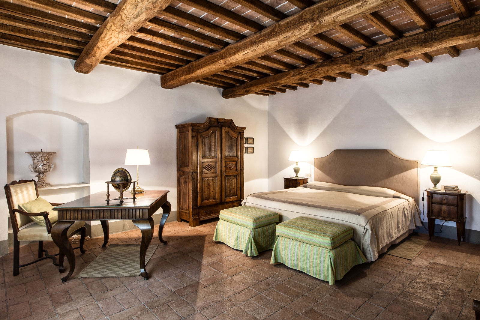 Bedroom with double bed, bedside tables, lamps, wardrobe, desk and chair at Il Prato di Vignamaggio in Tuscany, Italy