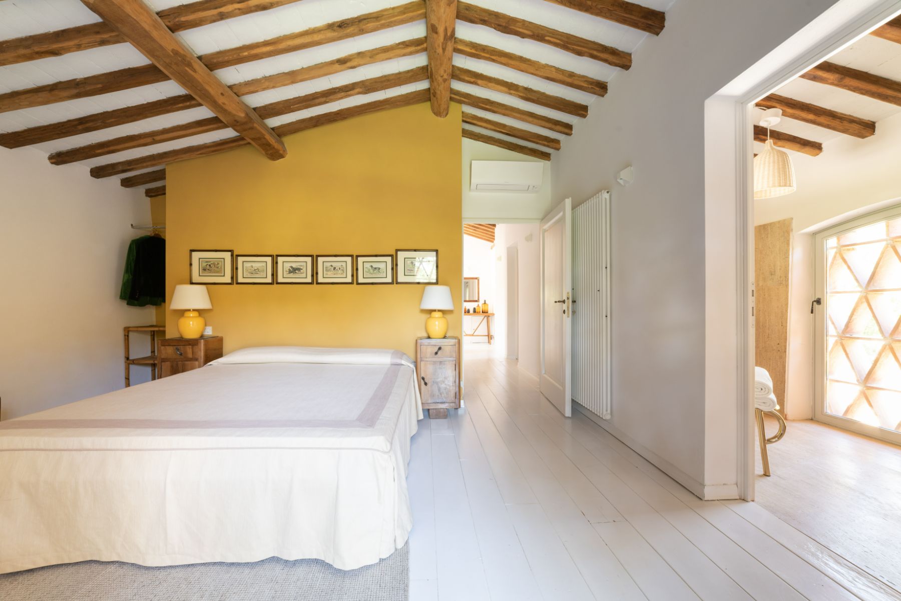 Ensuite bedroom with view of the bathroom and wooden beams at Il Prato di Vignamaggio in Tuscany