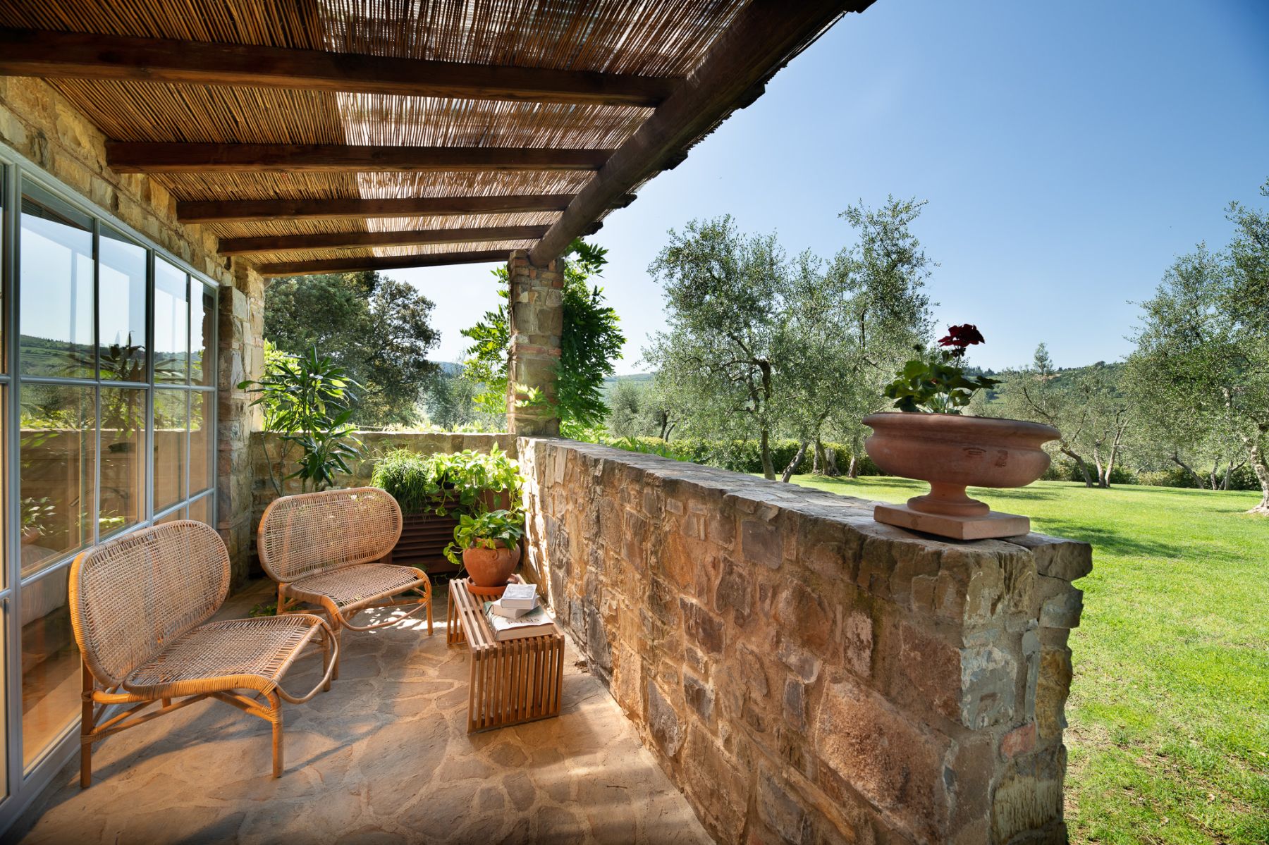 Balcony at the studio suite with two chairs and a stone wall at Villa Il Prato di Vignamaggio in Tuscany