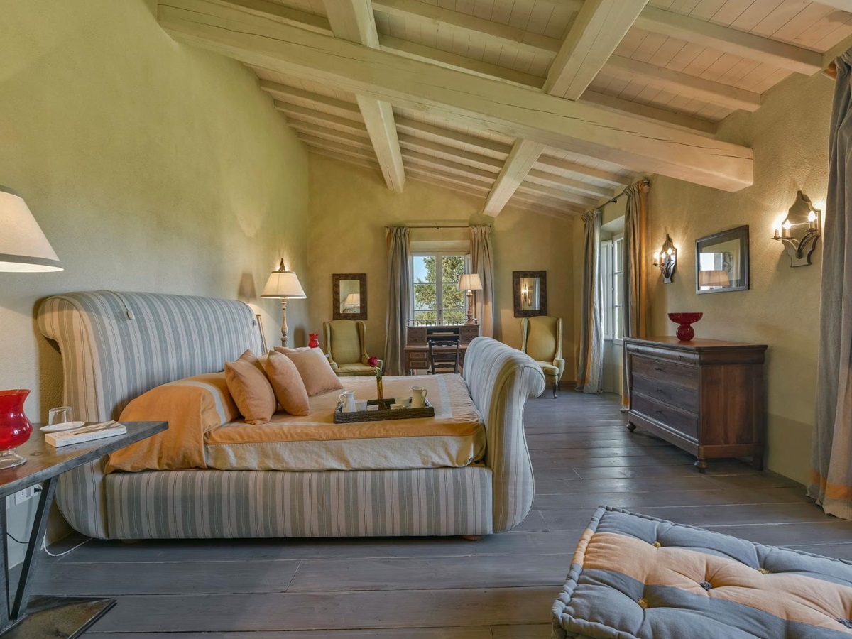 Bedroom in villa Il Serratone in Tuscany, with large striped bed and chest of drawers