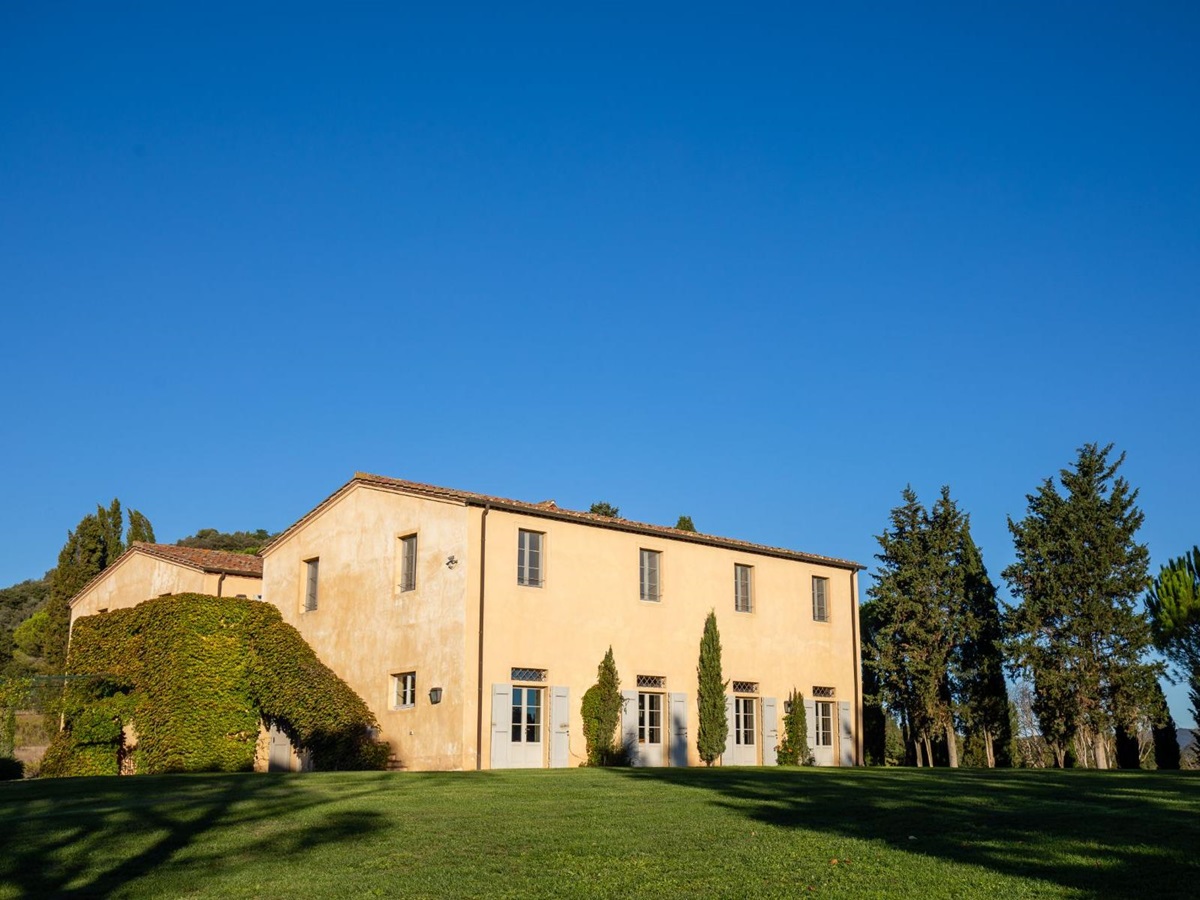 exterior view of villa Il Serratone building surrounded by trees in Tuscany