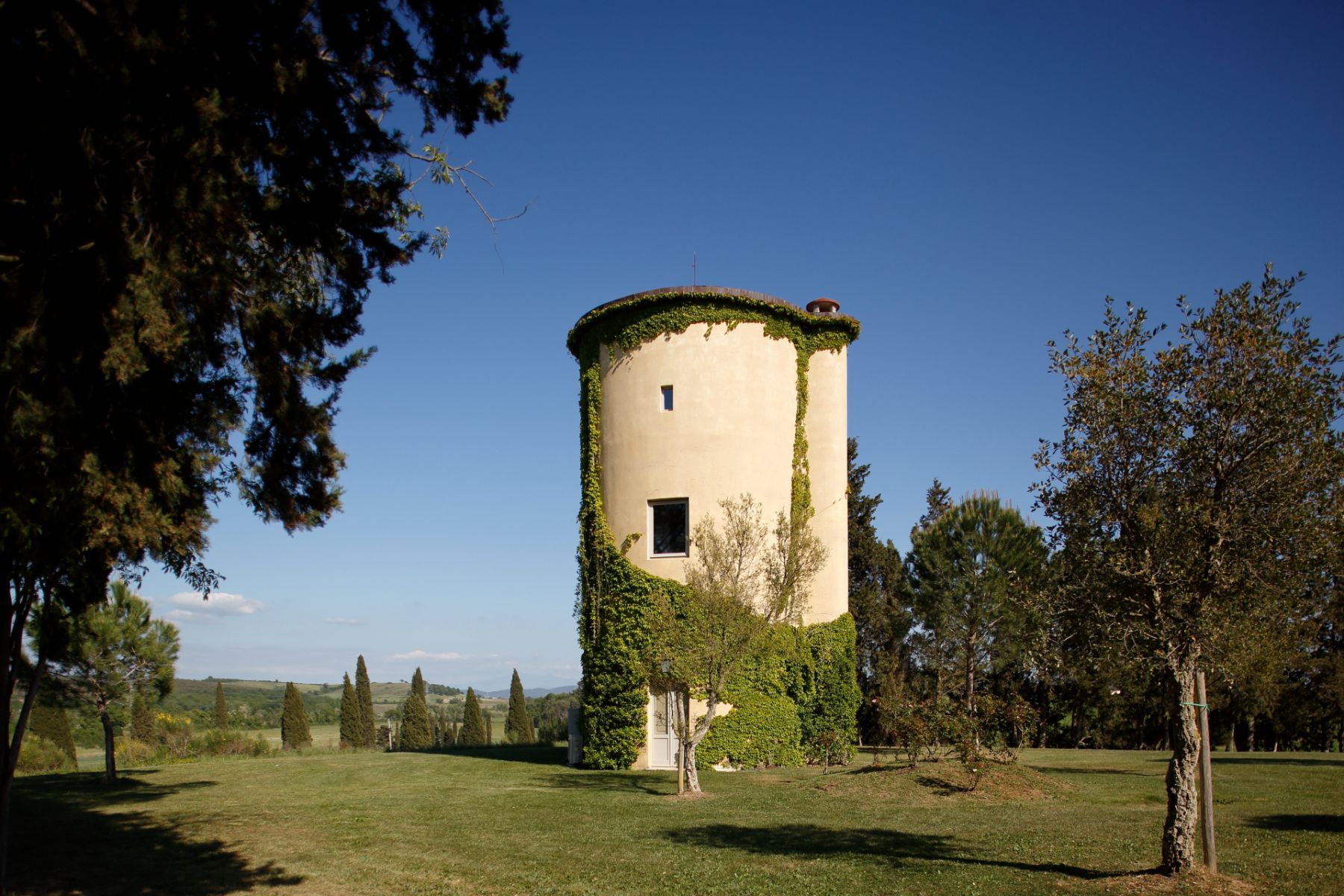 Outdoor view of the silo at villa Il Serratone in Tuscany surrounded by trees