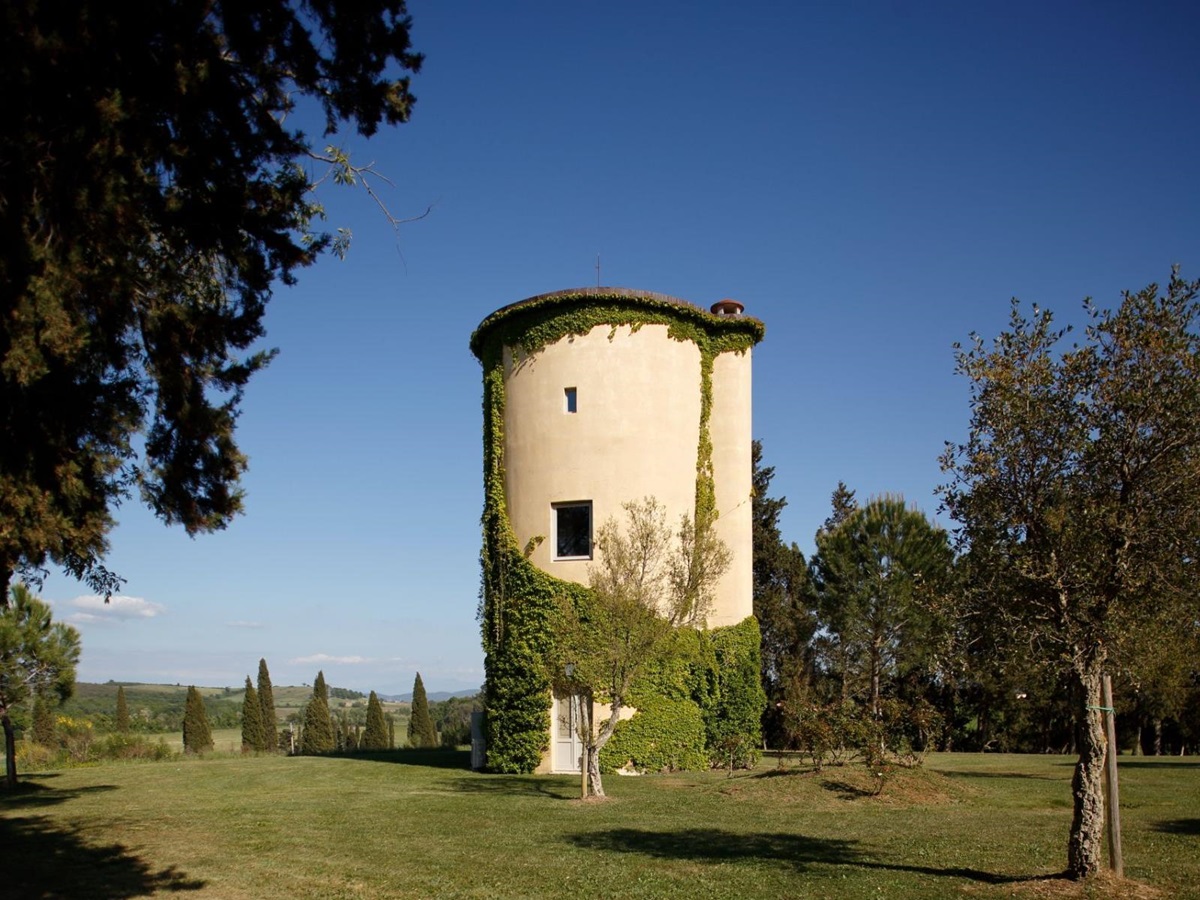 Outdoor view of the silo at villa Il Serratone in Tuscany surrounded by trees