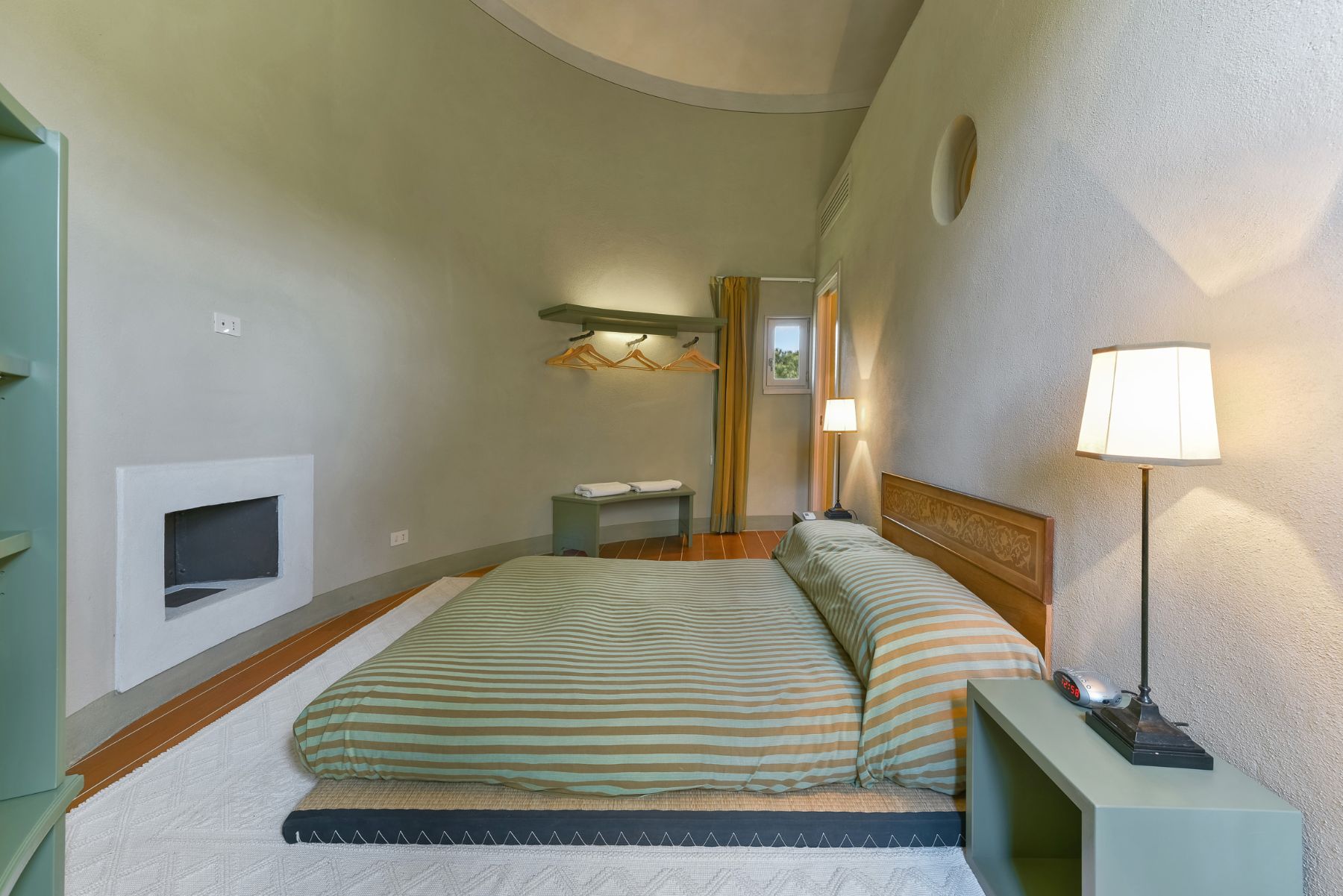 Bedroom with double bed in the silo at villa Il Serratone in Tuscany