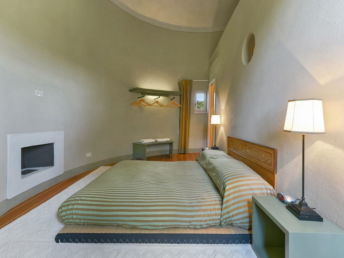 Bedroom with double bed in the silo at villa Il Serratone in Tuscany