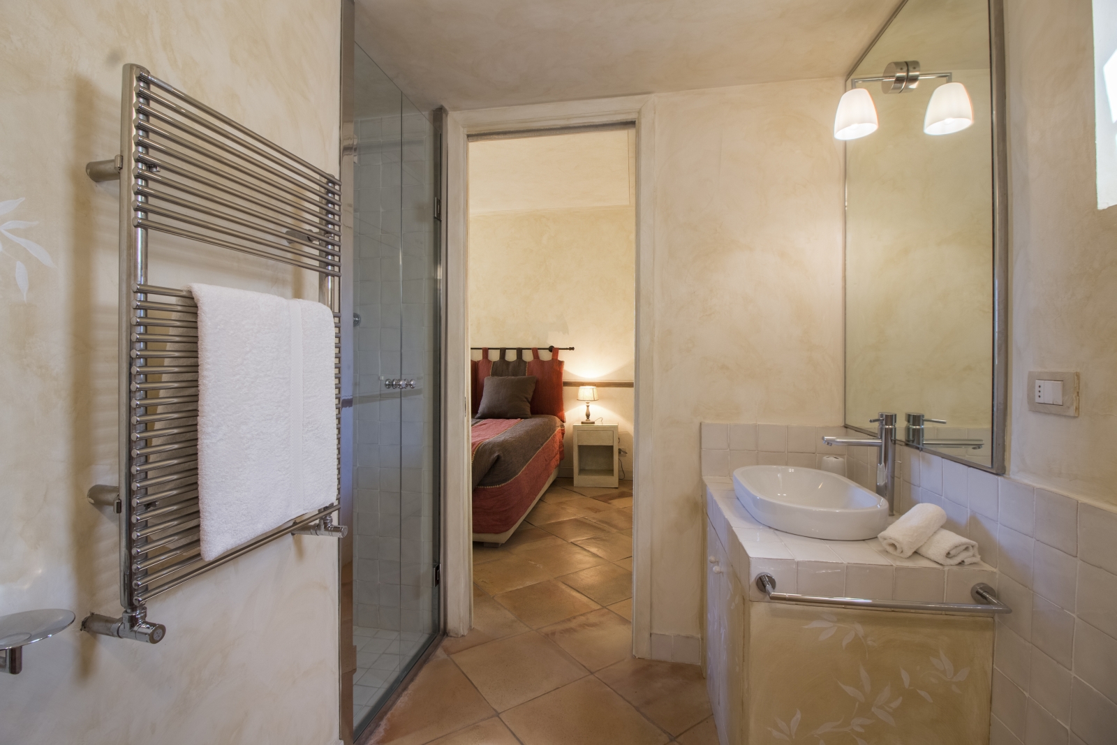 Bedroom with ensuite bathroom with towel rail, shower and sink at La Feniglia in Porto Ercole in Tuscany