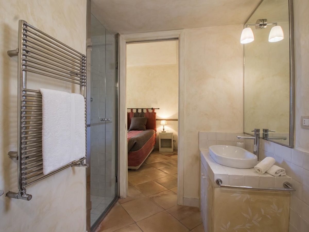 Bedroom with ensuite bathroom with towel rail, shower and sink at La Feniglia in Porto Ercole in Tuscany